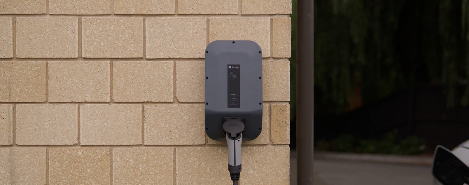 Borne de recharge murale posée en façade d'une maison