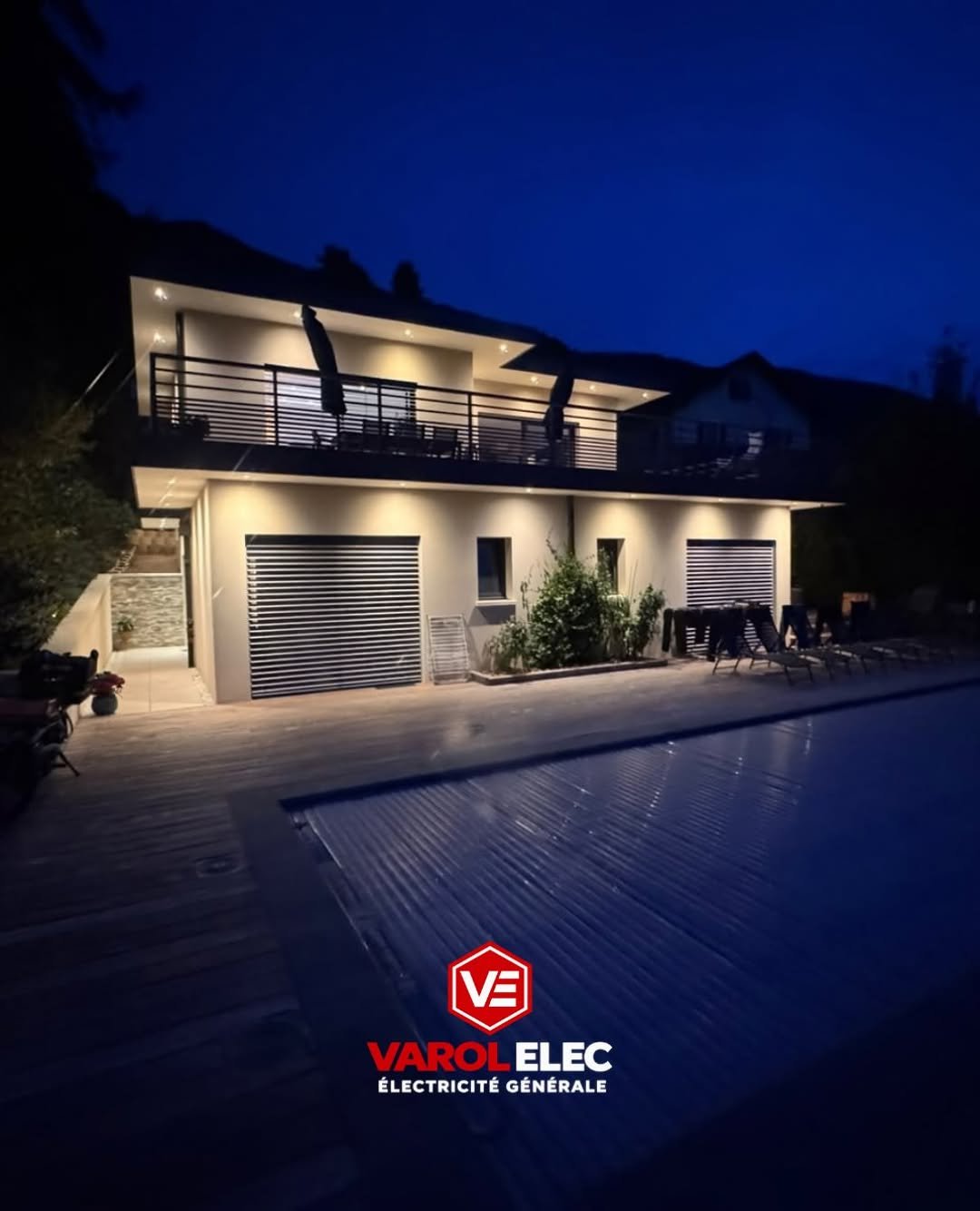 Façade de maison éclairée de nuit par des spots encastrés, au bord d'une piscine — réalisation Varol Elec