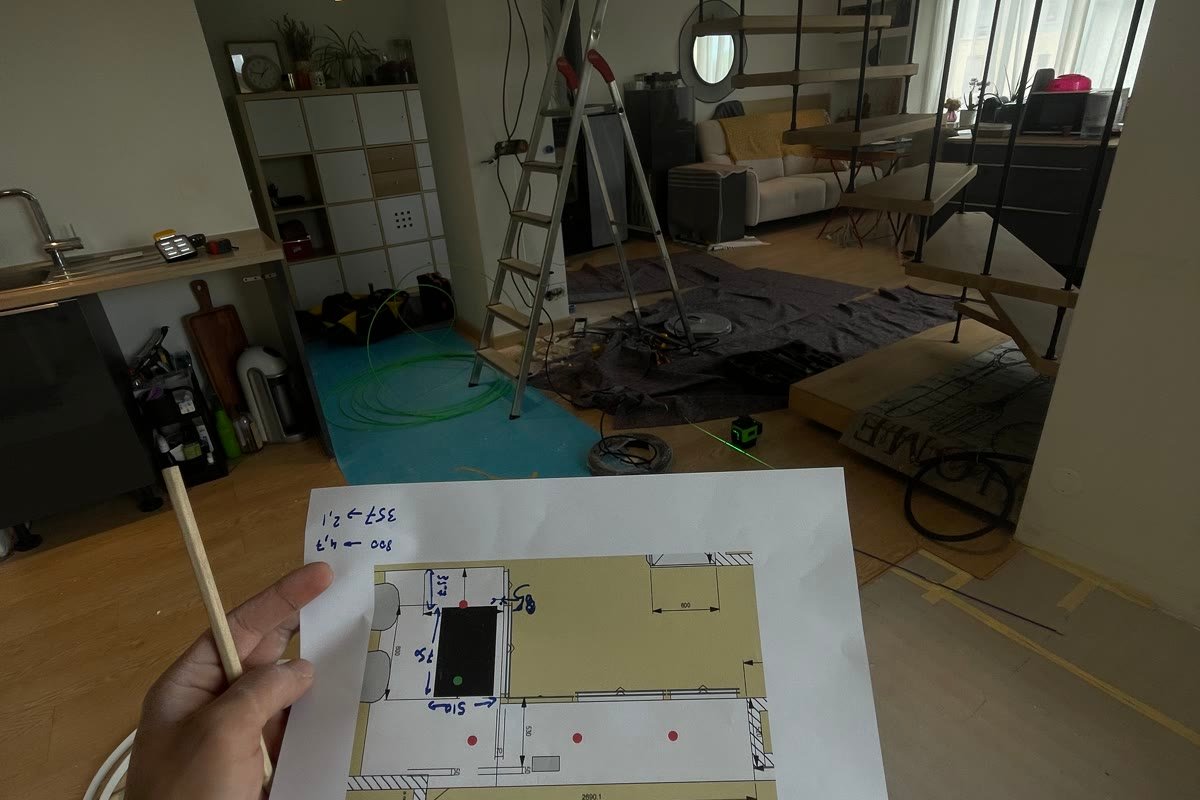 Plan de l'installation en main, sur un chantier de rénovation à Annecy