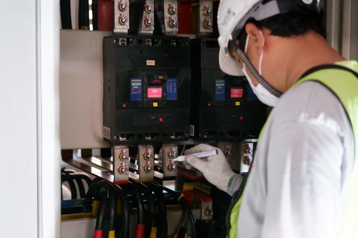 Technicien intervenant sur les disjoncteurs d'un tableau électrique